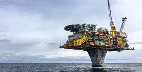 Uma grande plataforma de petróleo no meio do oceano.