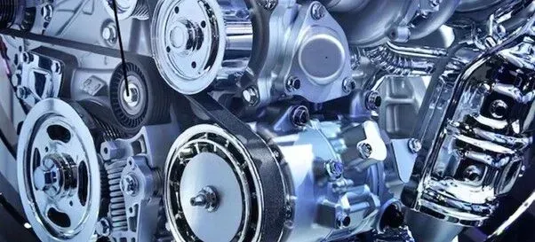 Um close-up de um motor de carro com muitas engrenagens e polias.