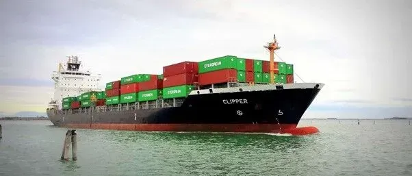 Um grande navio porta-contêineres está flutuando em cima de um corpo de água.