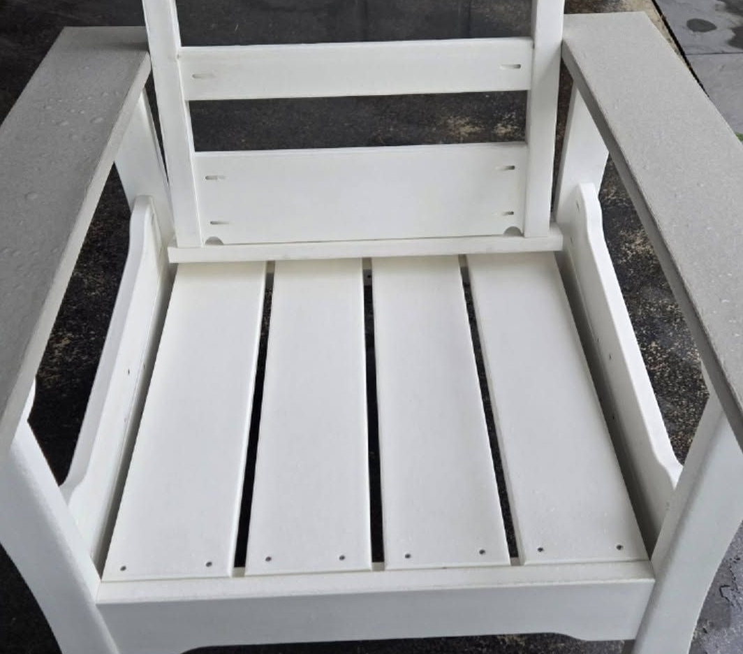 White wooden chair with slatted seat and backrest on a gray concrete surface