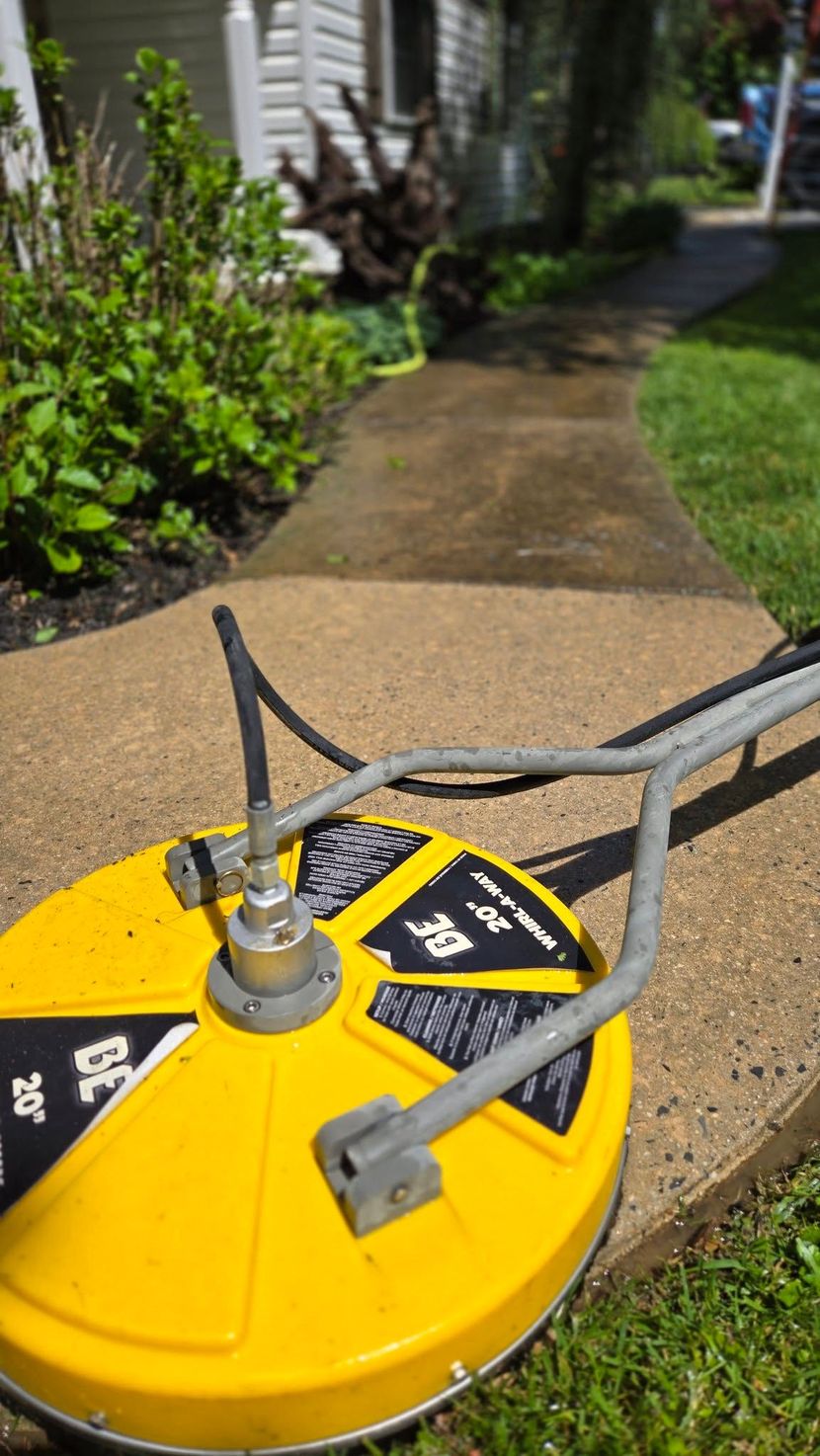 Yellow lawn sprinkler on a garden path, watering a landscaped yard