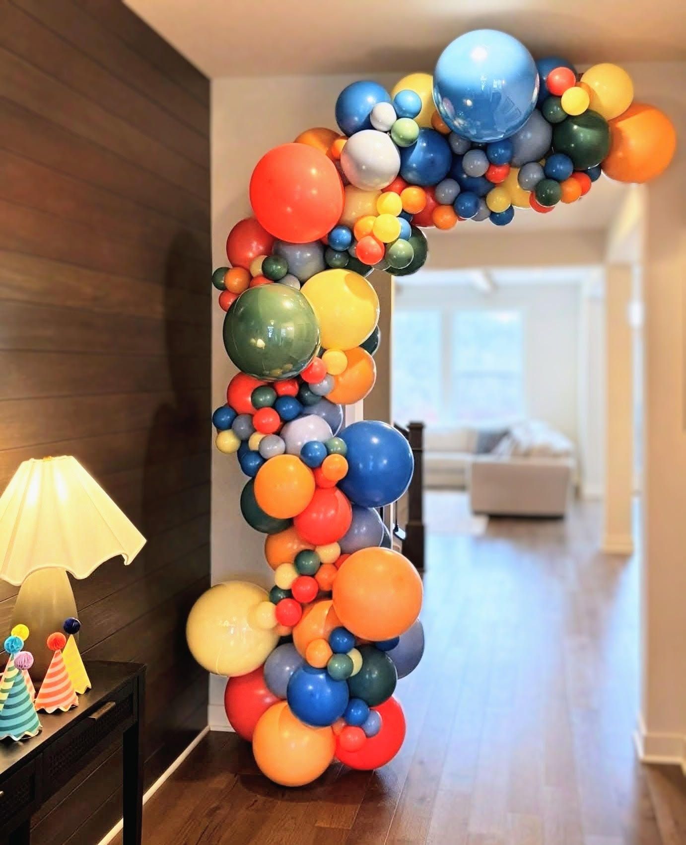 A festive balloon arch in blue, orange, yellow, and green