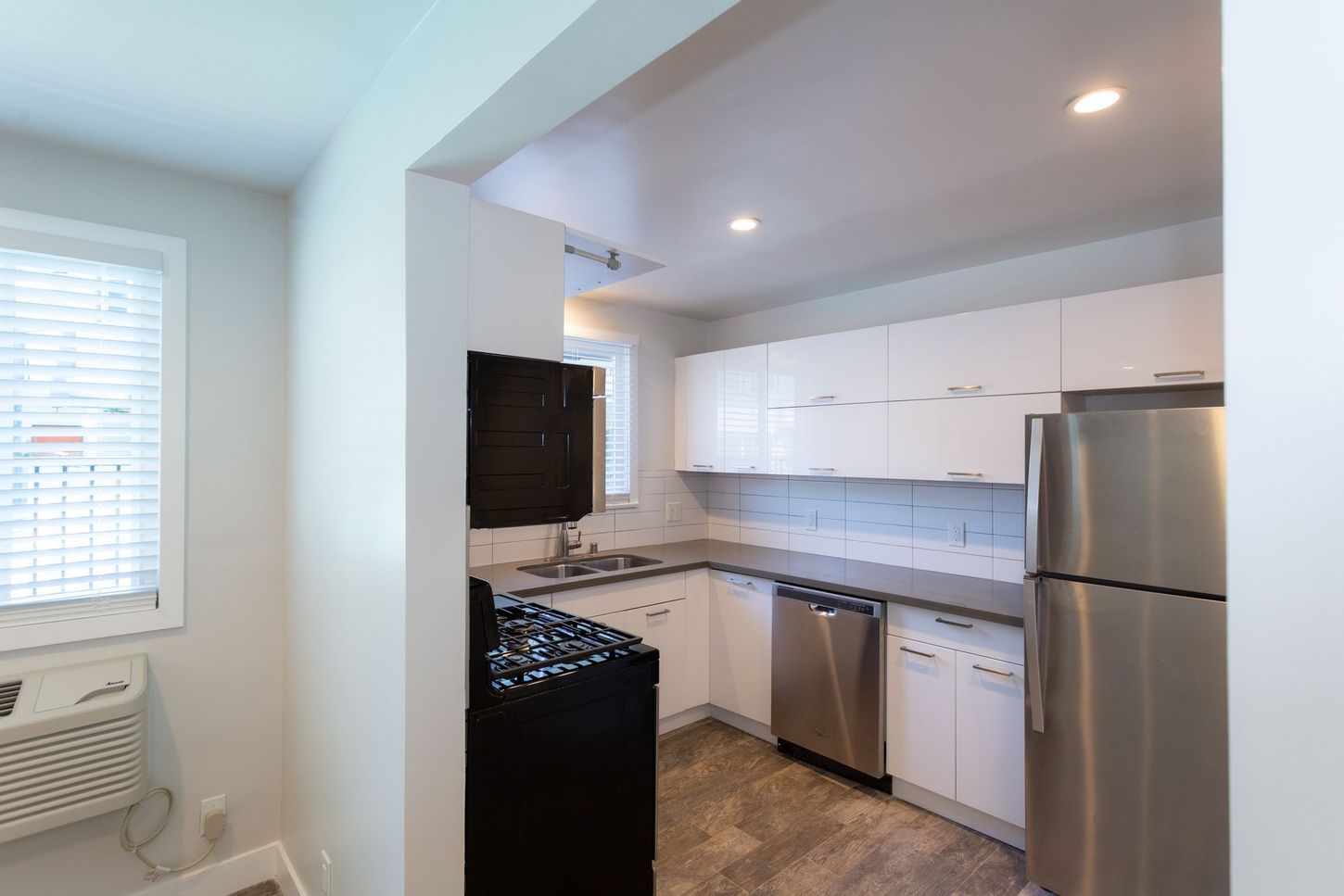 Bright modern kitchen with white cabinets, stainless steel appliances, and a tiled backsplash
