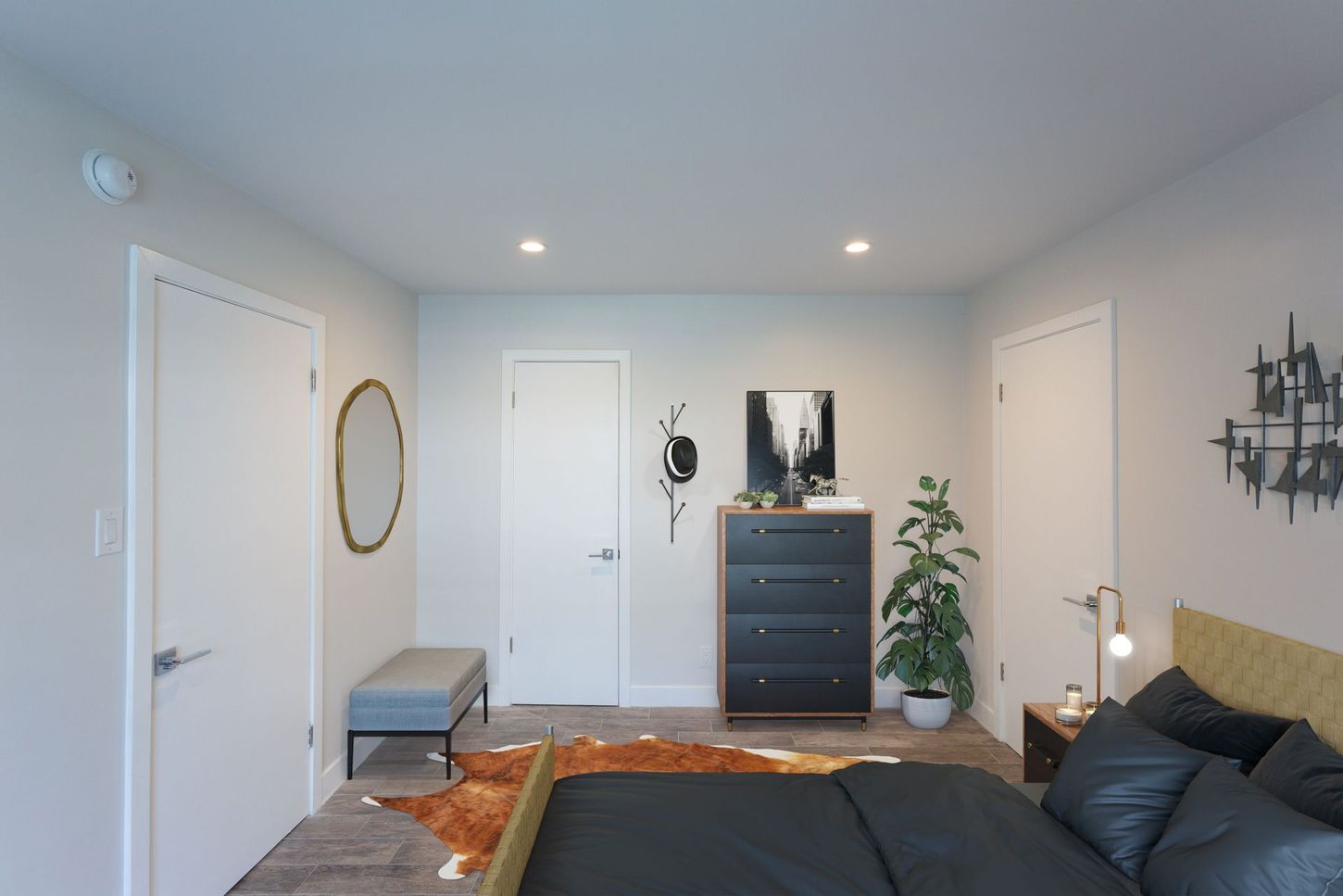 Minimal bedroom with gray walls, bed, dresser, mirror, plant, and wall decor