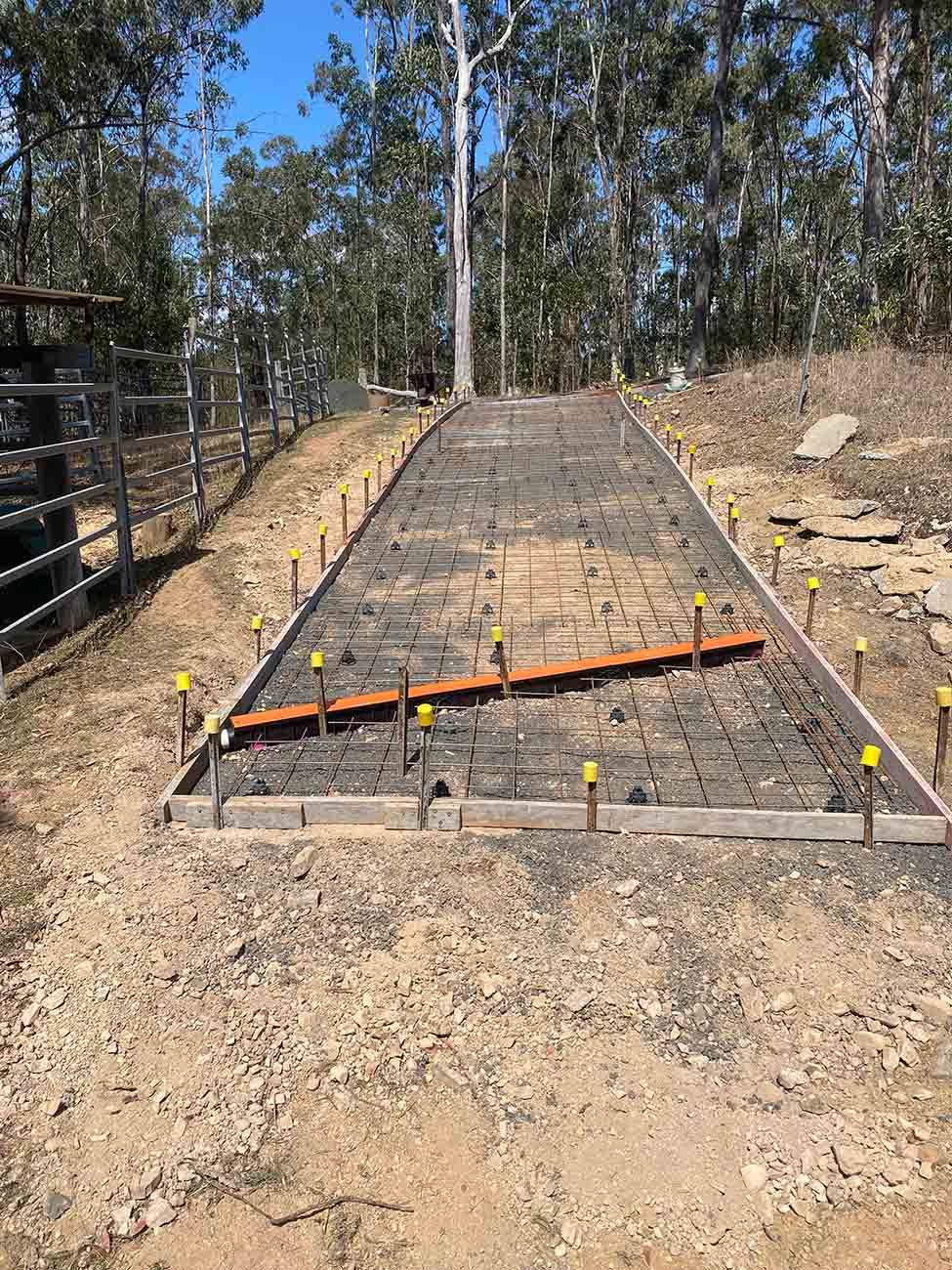 A Concrete Driveway Is Being Built in The Middle of A Dirt Field — Shaka Concreting In Tweed Heads, NSW