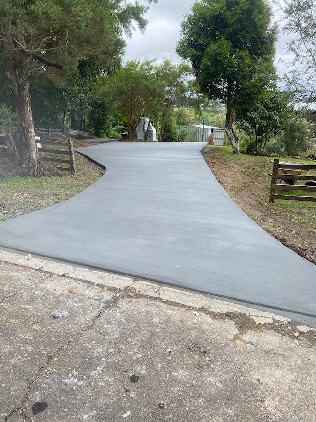 A Concrete Driveway Next to Some Trees — Shaka Concreting In South Golden Beach, NSW