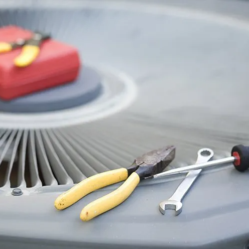 Receive 2 free tune-ups on your heat and air unit throughout the year Tools sitting on top of AC unit while it is getting repaired
