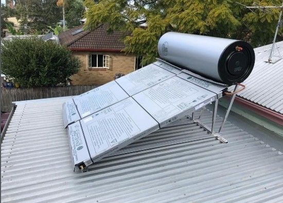 Solar hot water system on a metal roof; a rectangular panel angled towards the sky with a cylindrical tank.