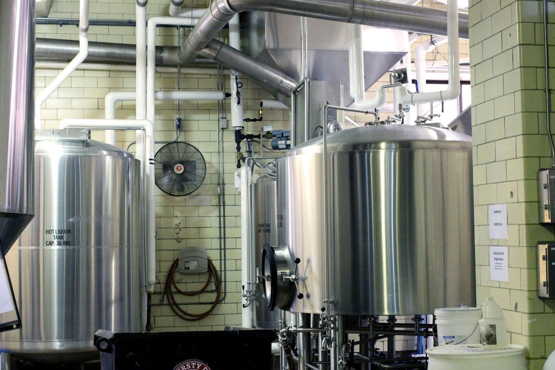 Stainless steel industrial tanks and pipes in a brewery or processing room