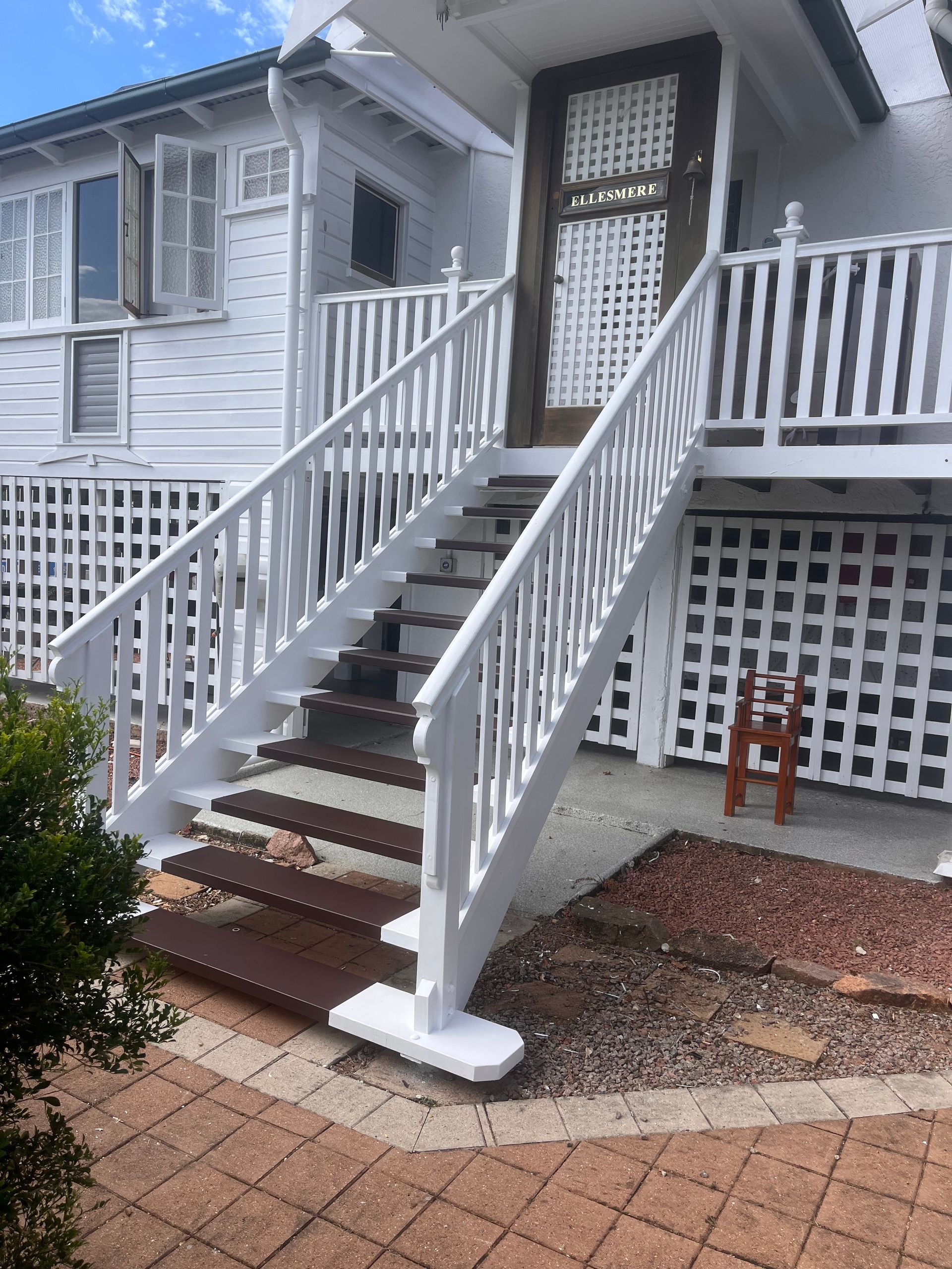 House Front Entrance with Stairs, Railings, and A Small Porch Over a Brick Walkway — SS Building Services in Townsville, QLD