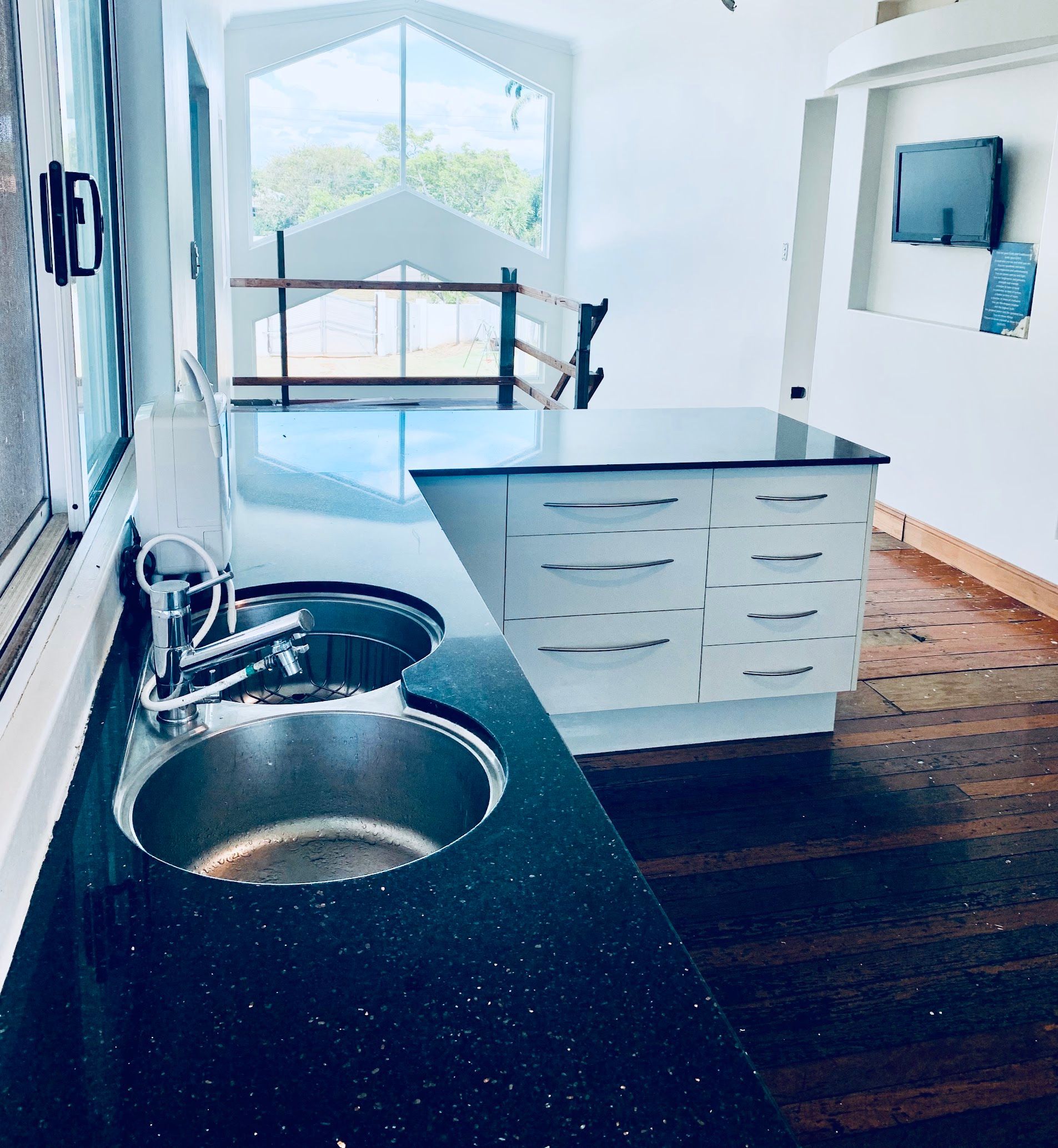 Bright Modern Kitchen with Island and Large Windows — SS Building Services in Townsville, QLD
