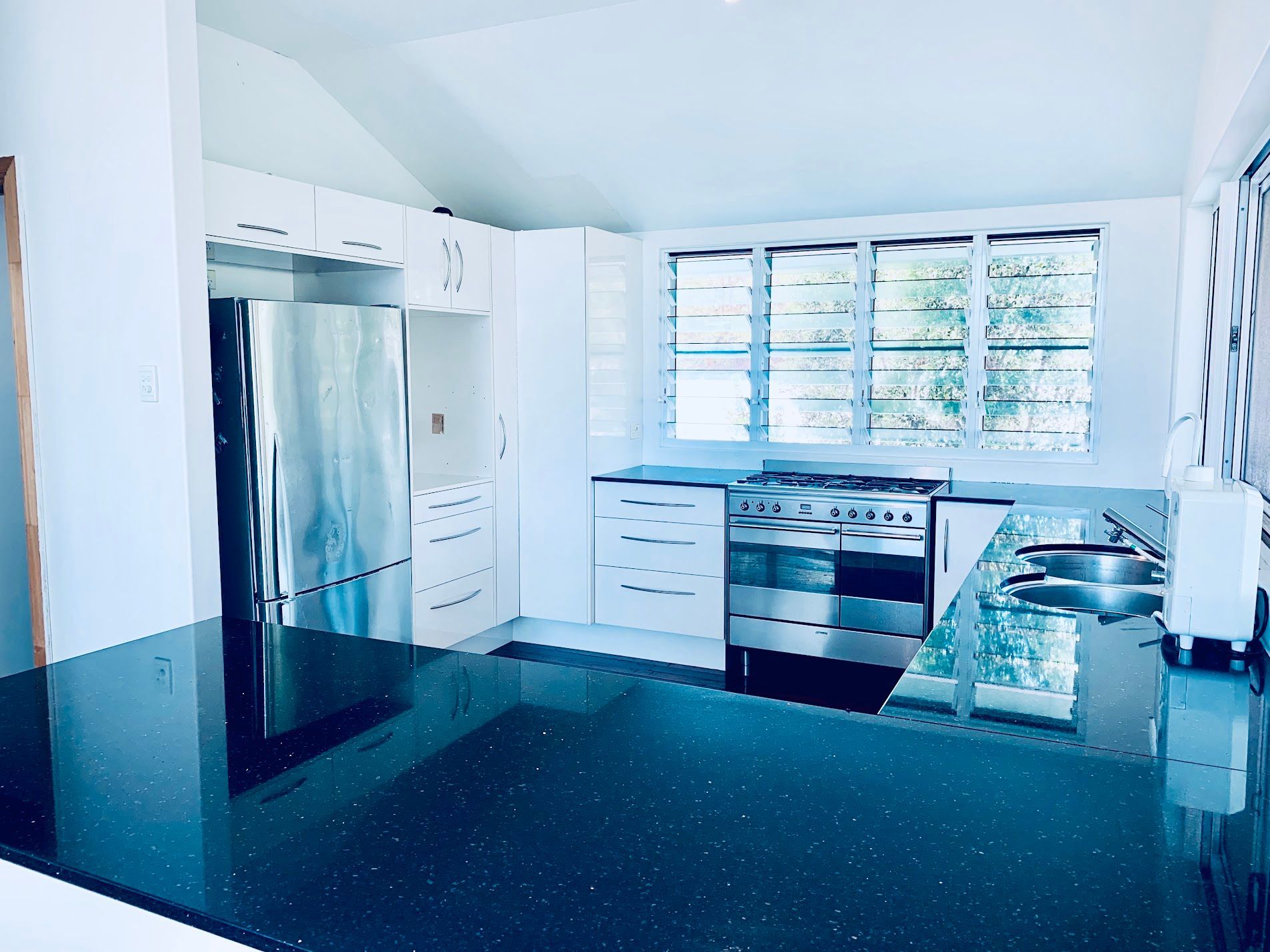 Modern Kitchen with White Cabinets and Stainless Steel Appliances — SS Building Services in Townsville, QLD