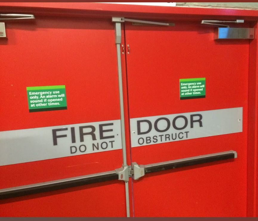 A Man is Using a Drill to Install a Door Lock — SS Building Services in Townsville, QLD