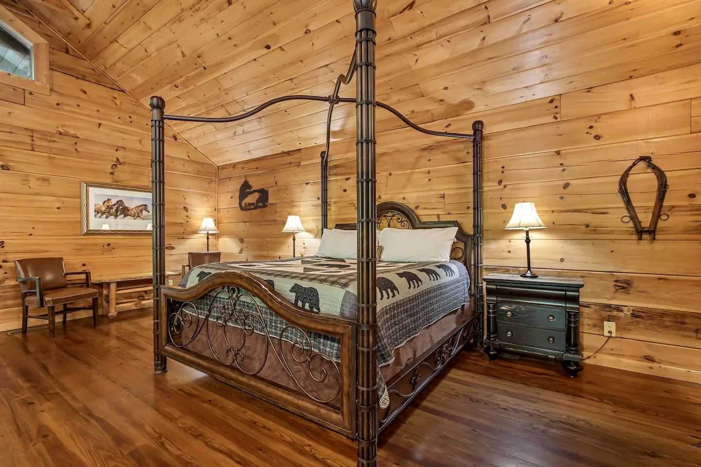 Rustic wood-paneled bedroom with ornate four-poster bed, nightstands, lamps, and wooden floor