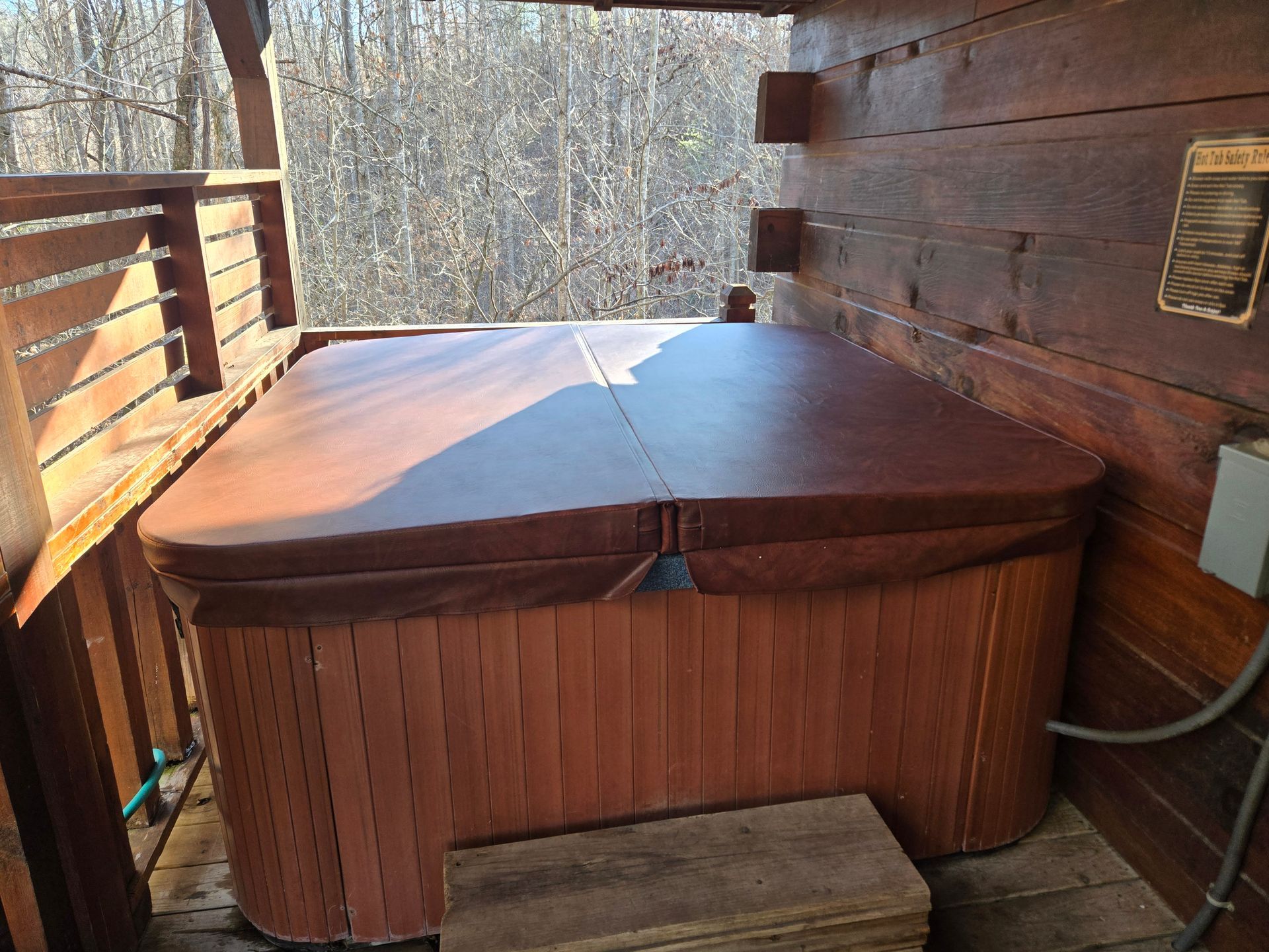 Wooden hot tub spa nook with a green French door and rustic cabin walls