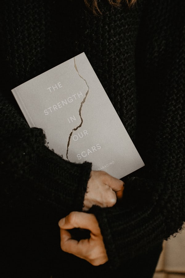 Person holding a book titled