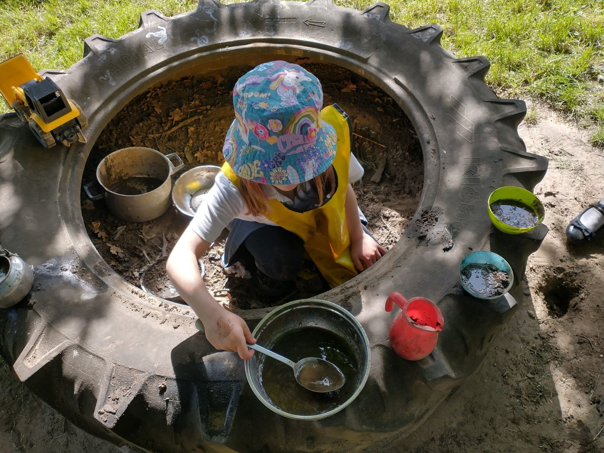 A child plays in a tractor tyre at Kudize childcare club