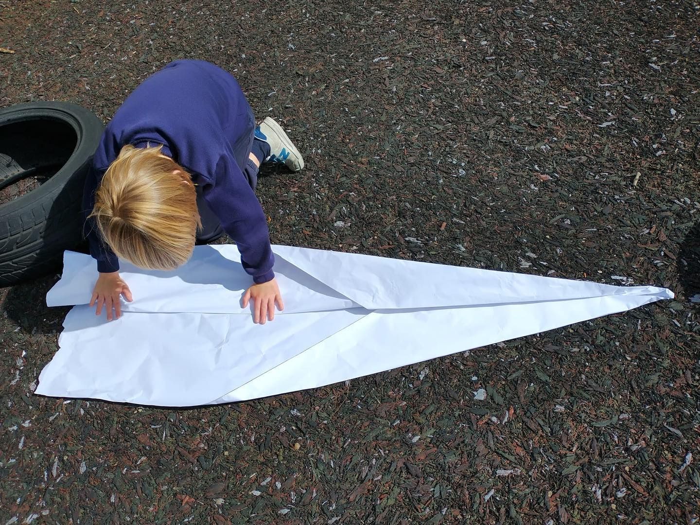 A child makes a giant paper plane at Kudize childcare provider