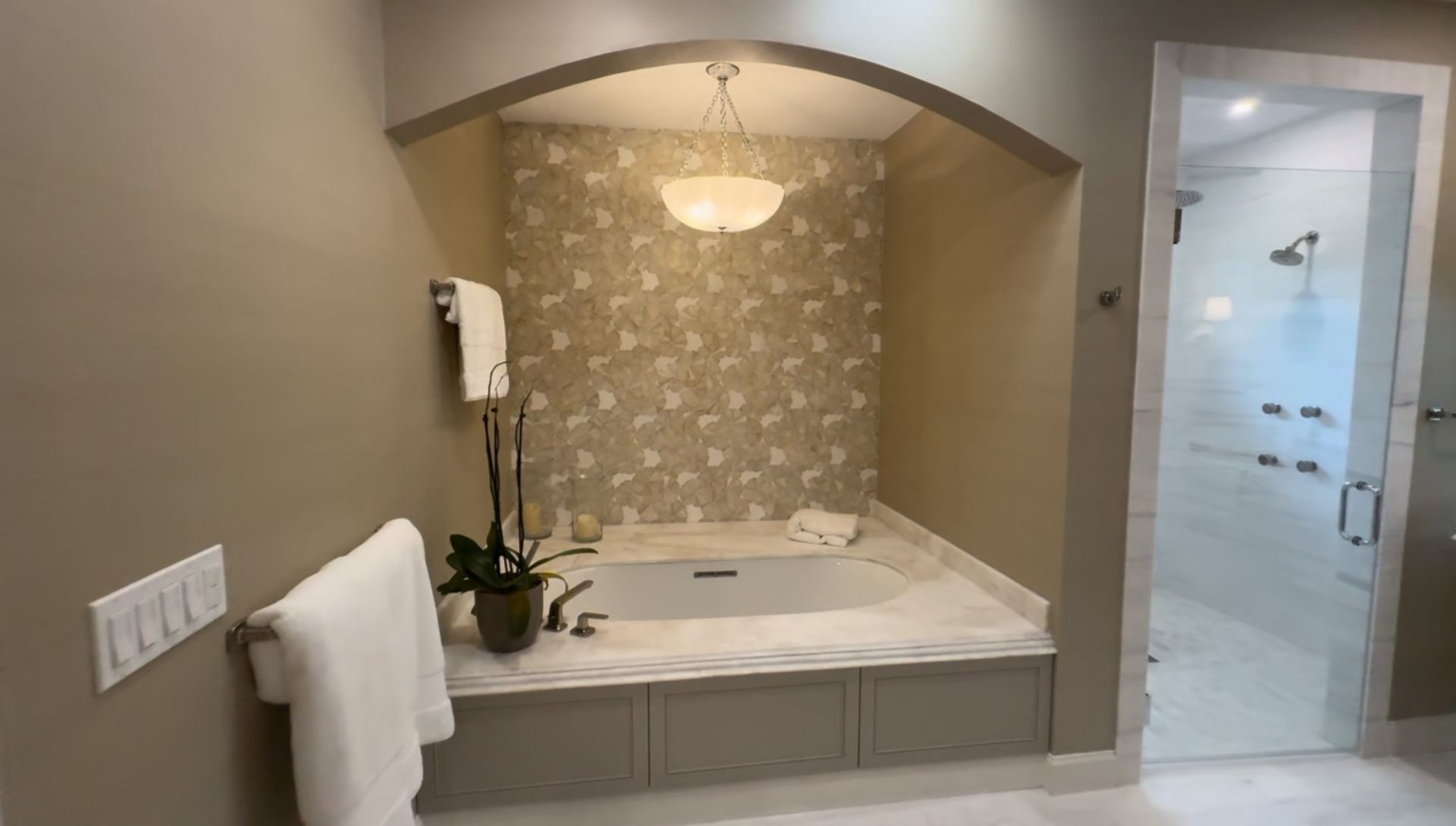 Elegant bathroom with a built-in soaking tub, tiled alcove, and adjacent glass-enclosed shower.