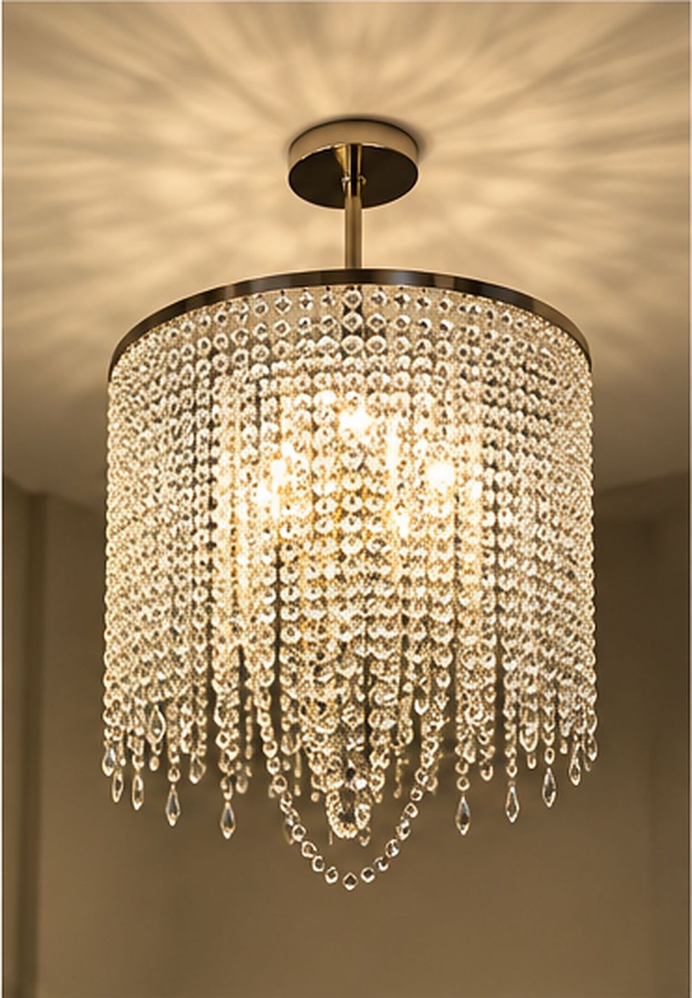 Lampadario scenografico sopra tavolo da pranzo con luce accogliente.