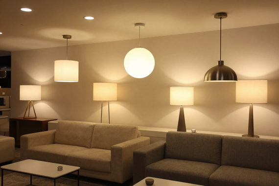 Showroom Living Illuminazione con scenari luce accesi, ambientazioni calde e arredi contemporanei.