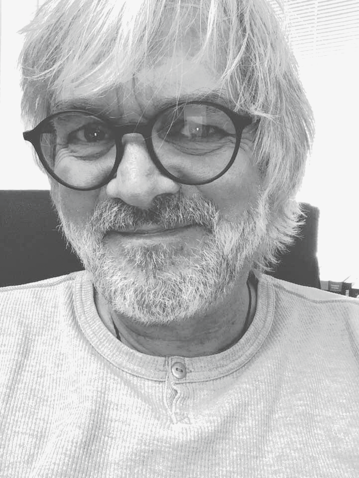 Ein Schwarzweißfoto eines Mannes mit Brille und Bart.