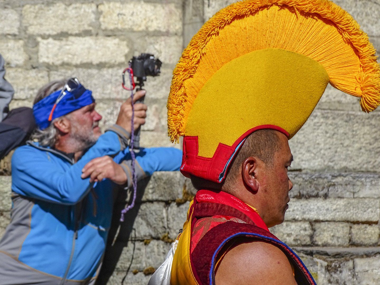 Ein Mann macht ein Foto von einem Mann, der einen gelb-roten Hut trägt