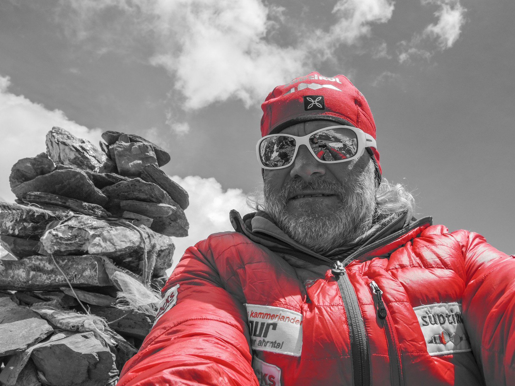 Ein Mann mit roter Jacke und Sonnenbrille macht ein Selfie