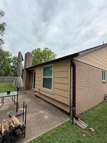 A house with a patio and umbrellas in front of it.