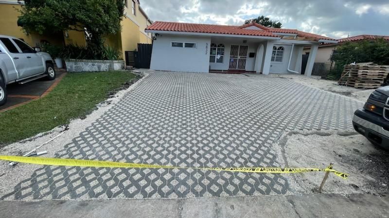 A car is parked in a driveway next to a house.