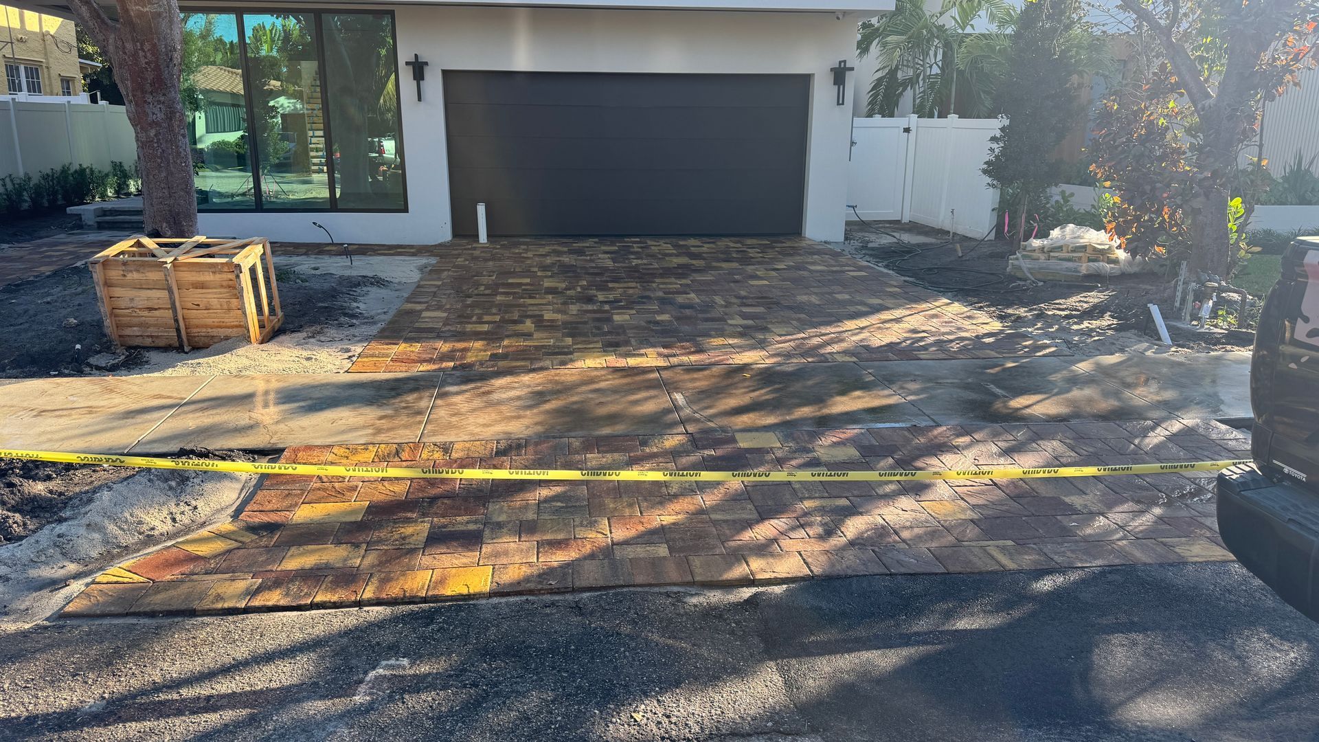 A brick driveway is being built in front of a house.