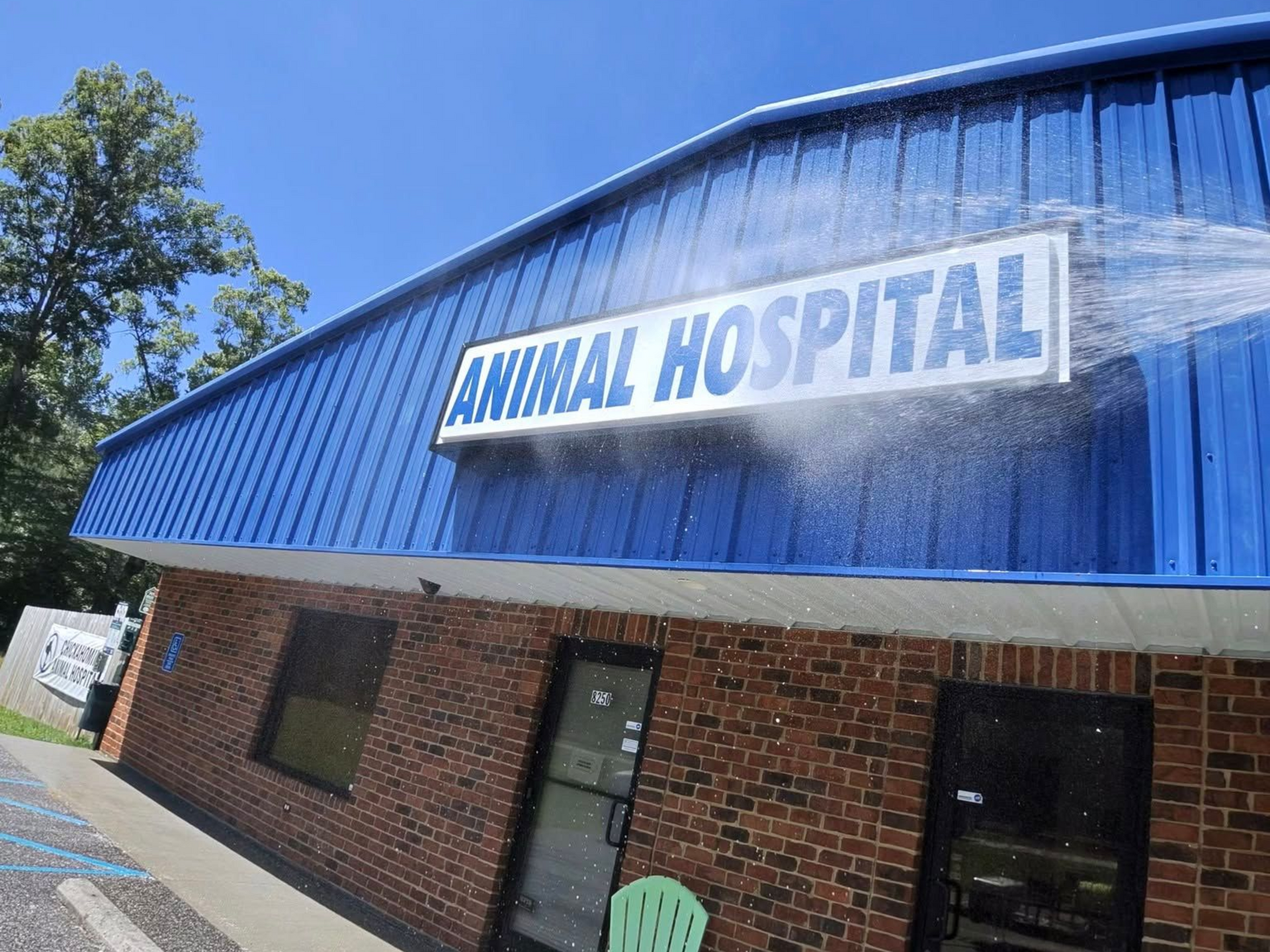 Blue brick animal hospital building with a white sign and blue roof awning