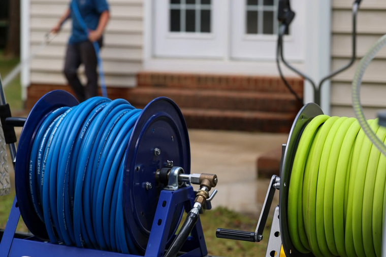 Blue and neon green cable reels on a lawn in front of a house