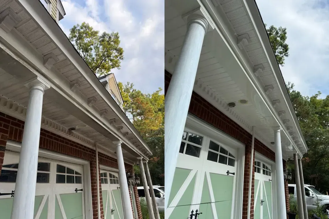 Tilted view of white-columned building facades with green garage doors and tree-lined roofline