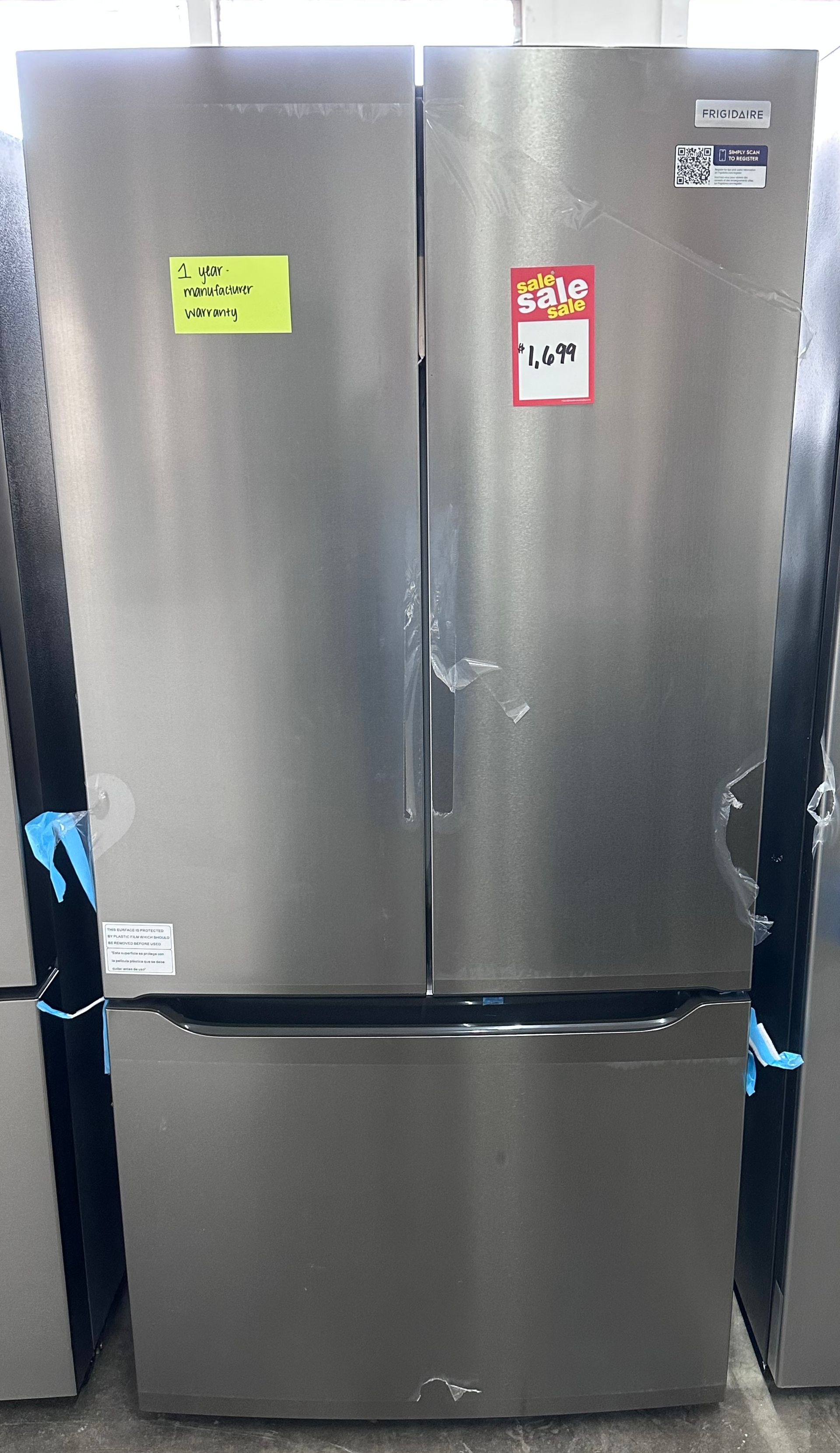 Stainless steel double-door refrigerator with bottom freezer in a kitchen or appliance display.