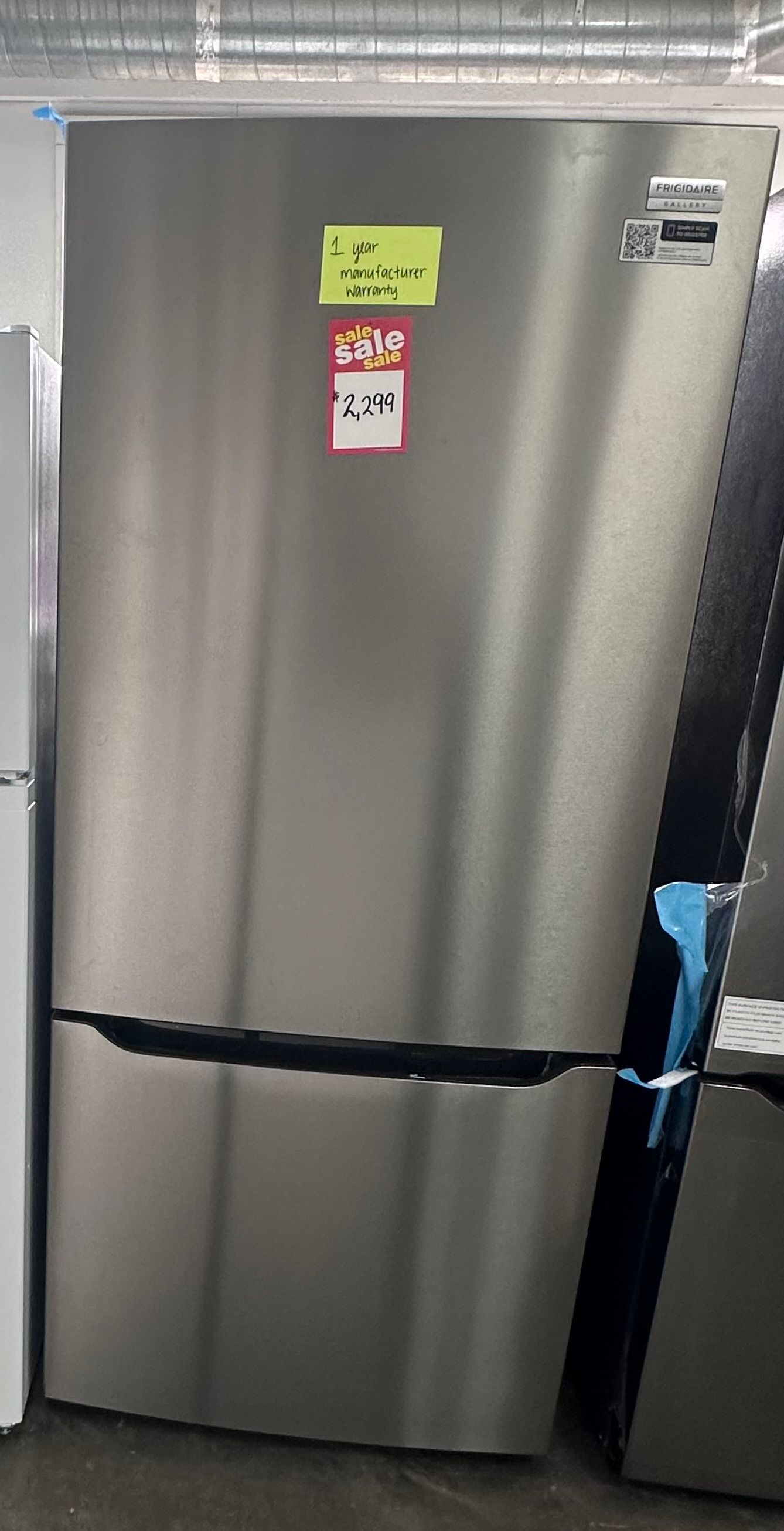 Stainless steel refrigerator with magnets on the door in a kitchen or appliance store