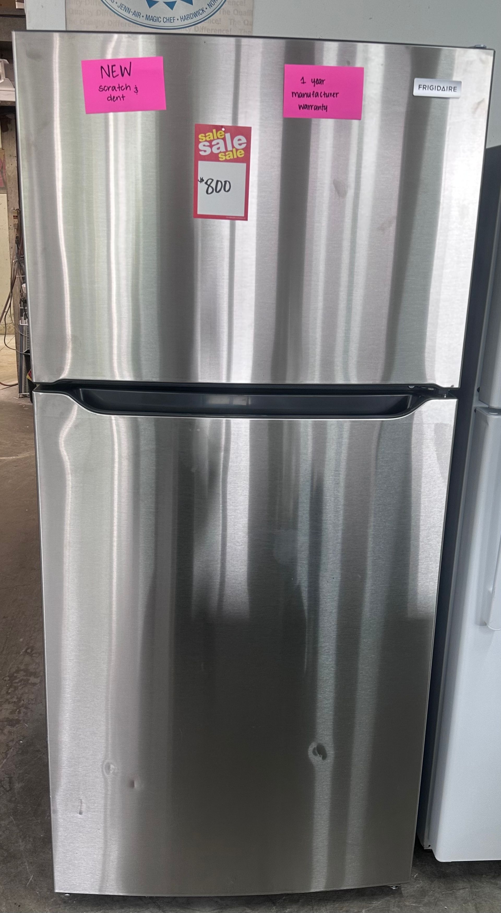 White French-door refrigerator with bottom freezer drawers and small labels on the doors
