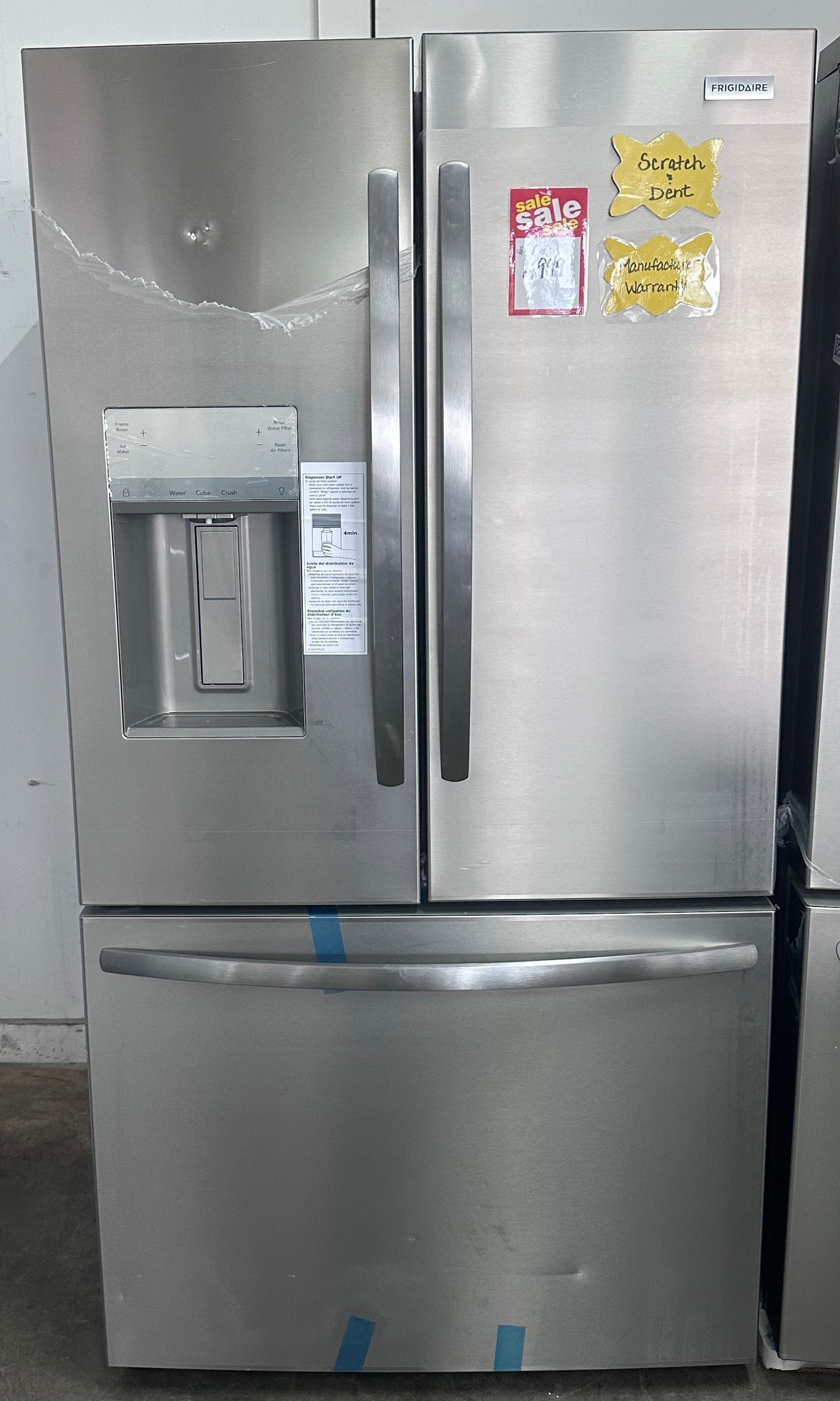 Stainless steel side-by-side refrigerator with water dispenser and stickers on the door