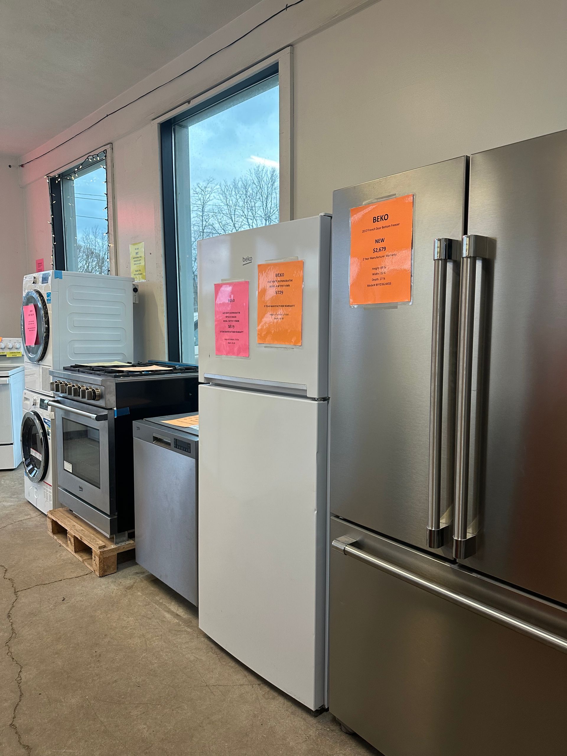 A row of refrigerators are lined up in a room.