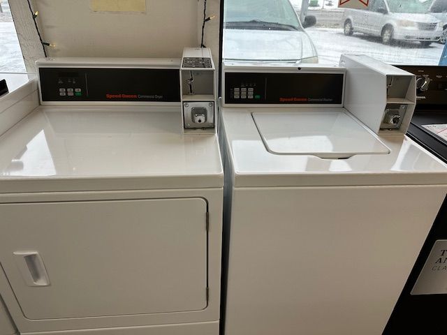 A washer and dryer are sitting next to each other in a laundromat.