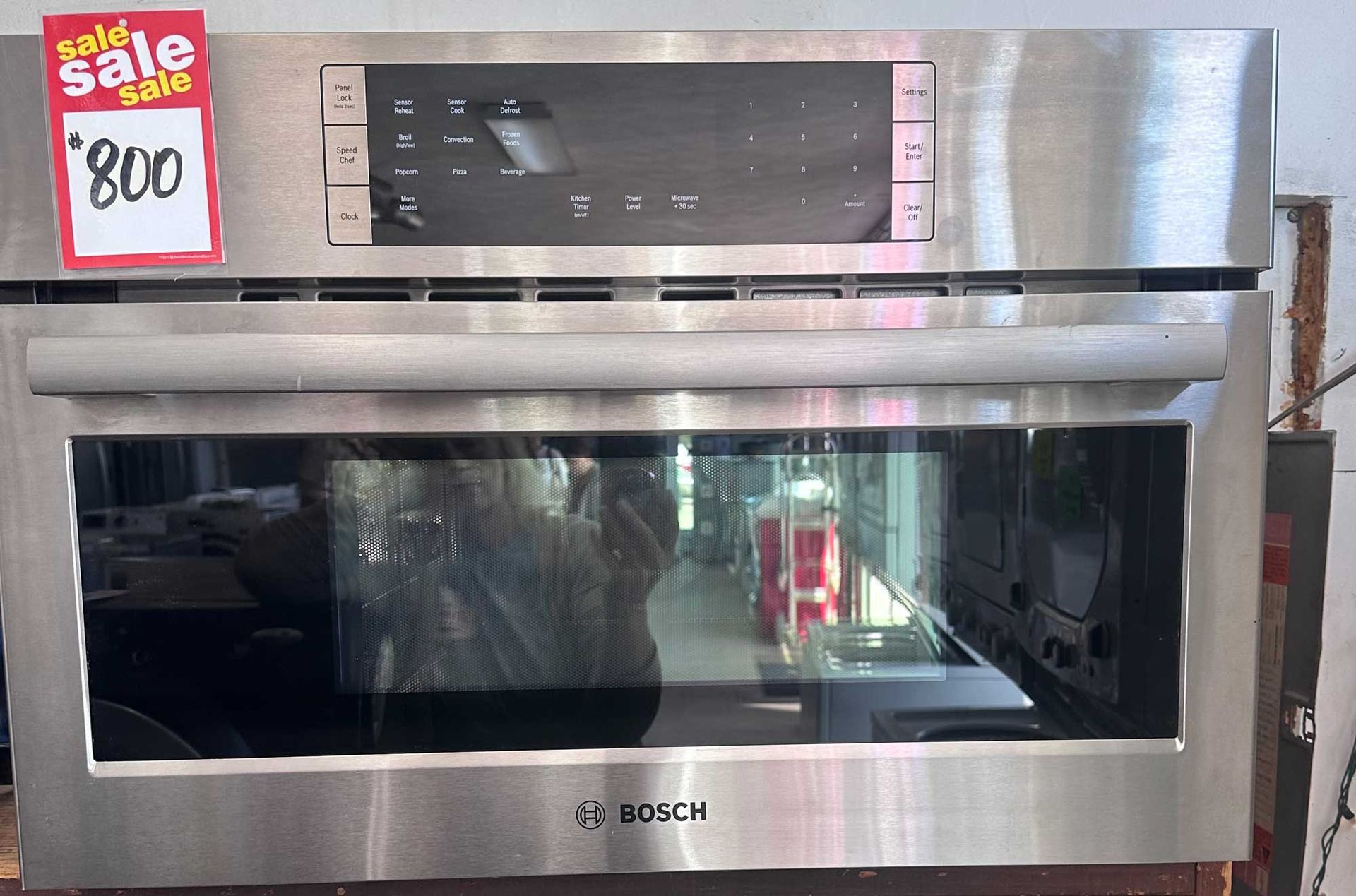 Stainless steel Bosch wall oven with digital display and sale tag showing $800