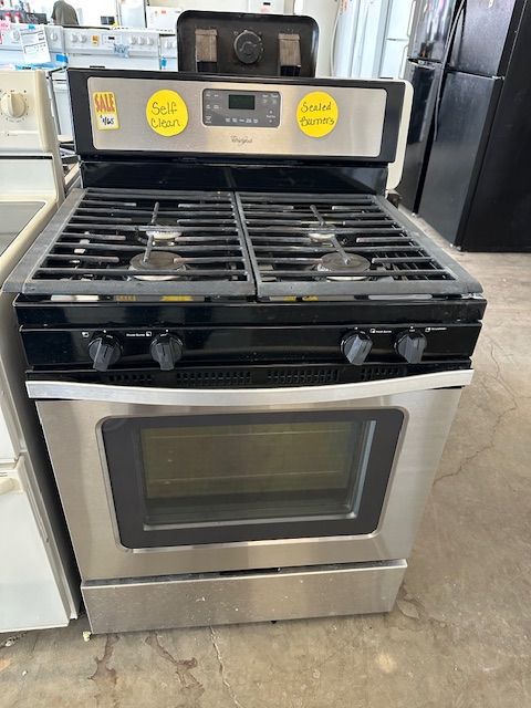 A stainless steel stove top oven is sitting on top of a concrete floor.