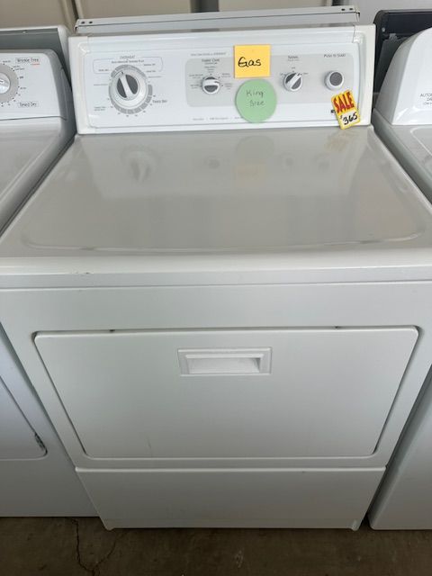 White clothes dryer in a laundry room with a top control panel and a front access door.