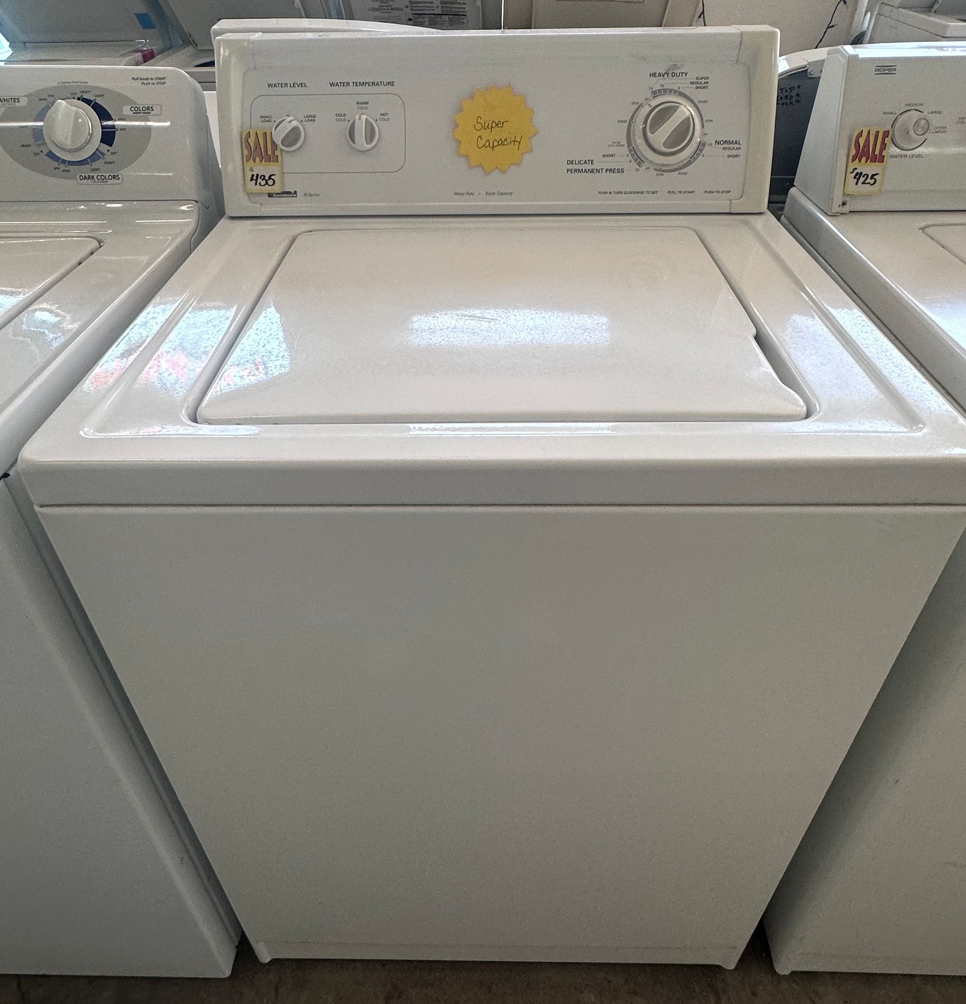 A stainless steel washing machine with a black door