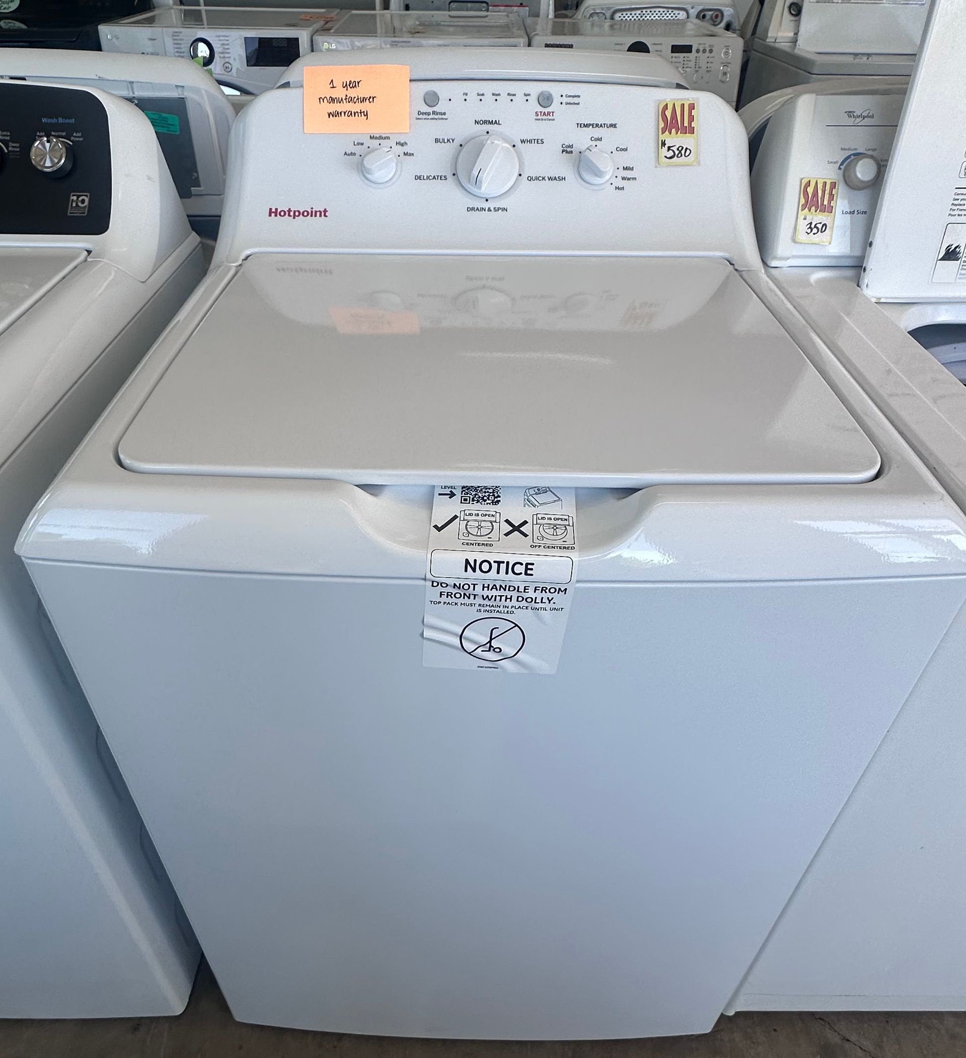 A stainless steel washing machine with a black door
