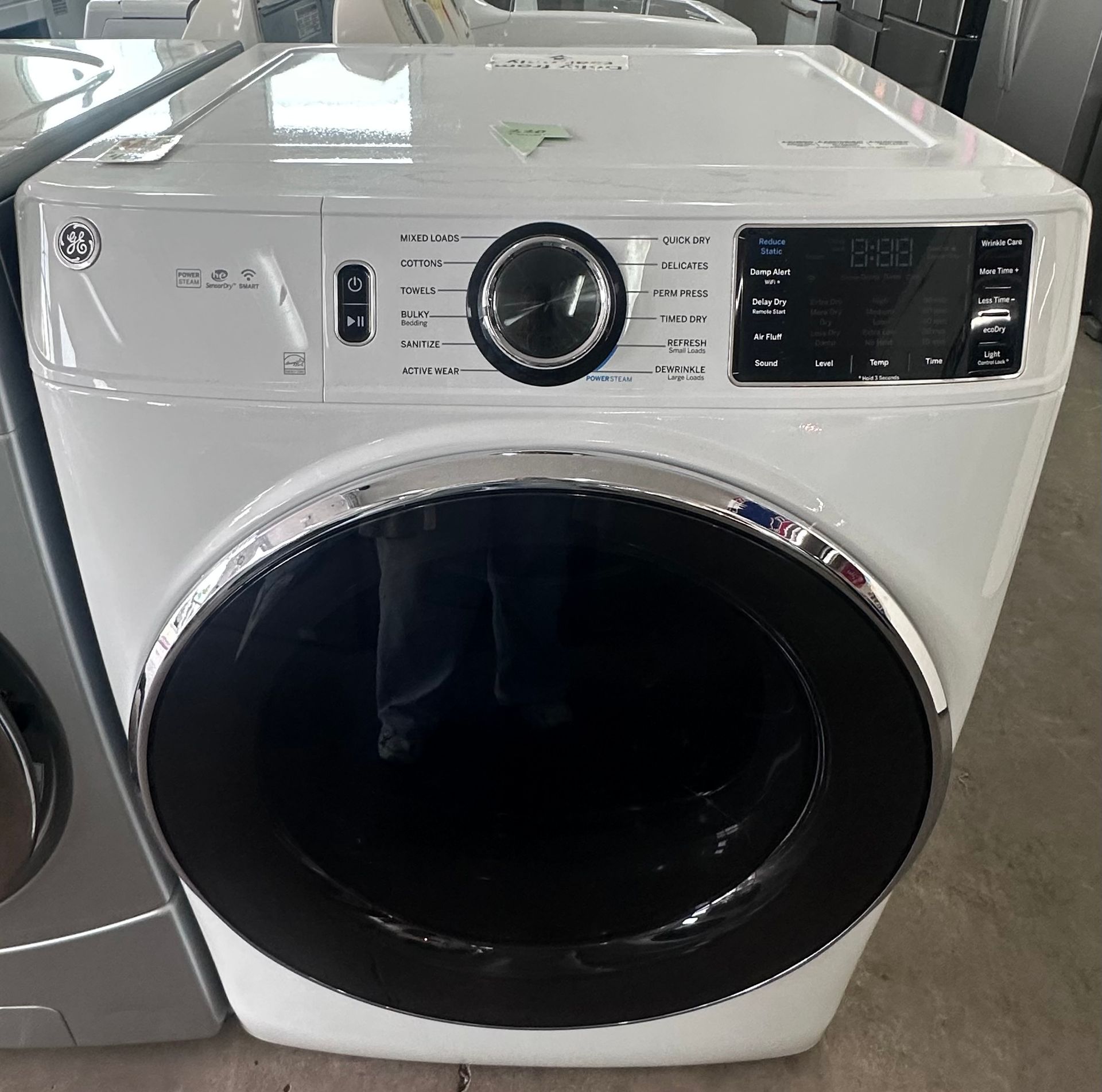 A white dryer is sitting on top of a counter in a laundry room.