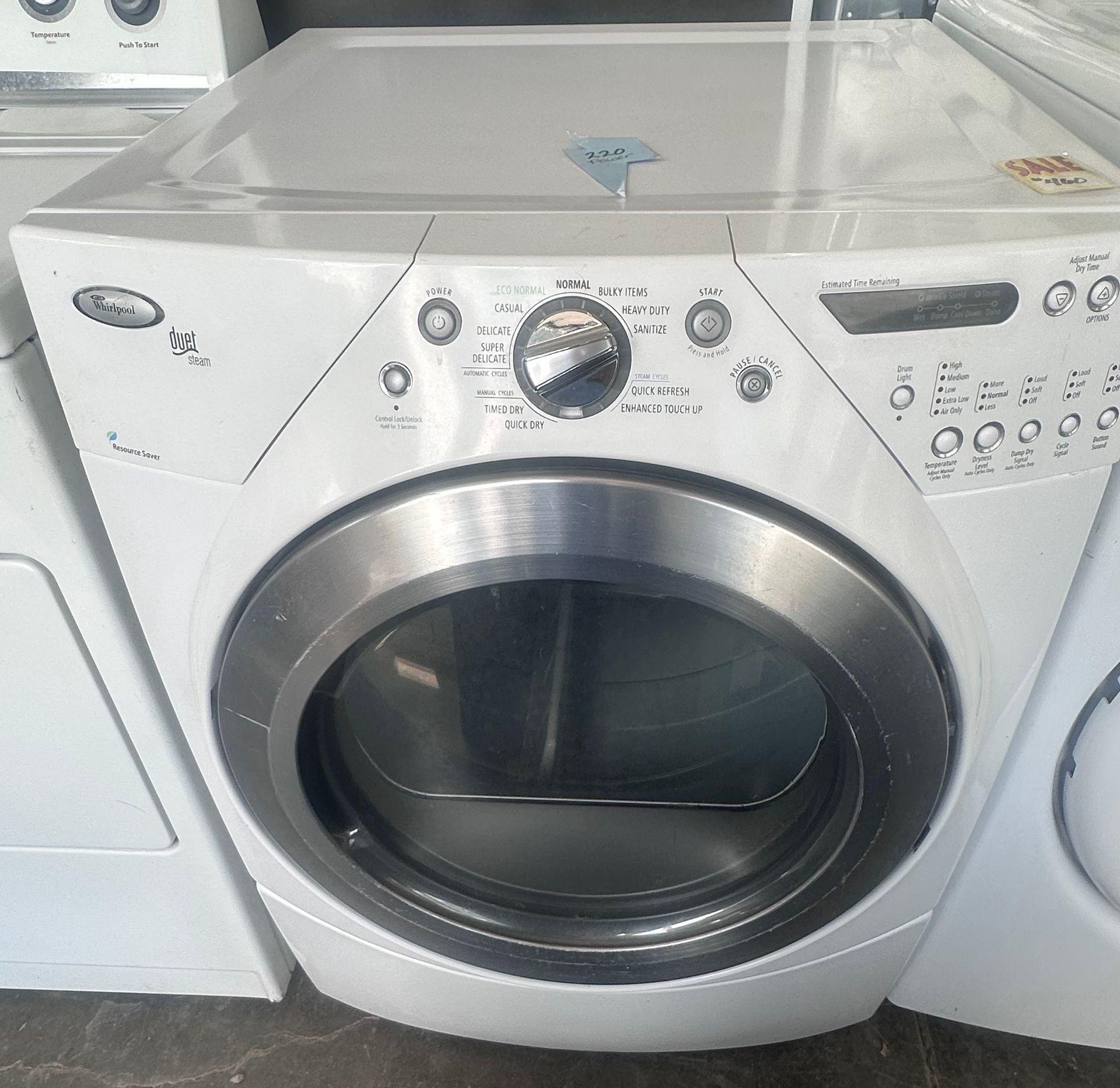 Front-load washer with silver trim and control panel in a laundry room