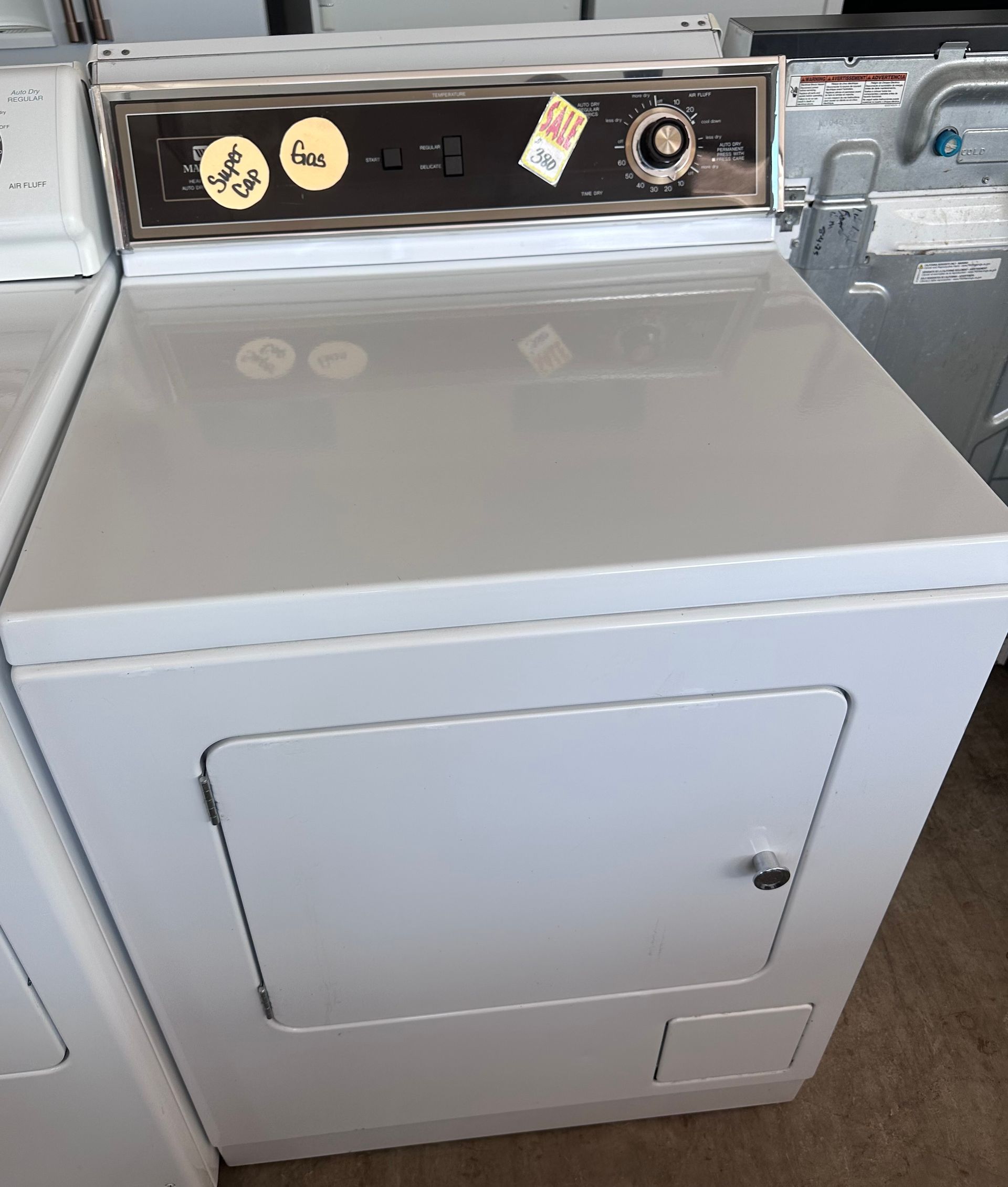 White electric clothes dryer with a control panel and door.