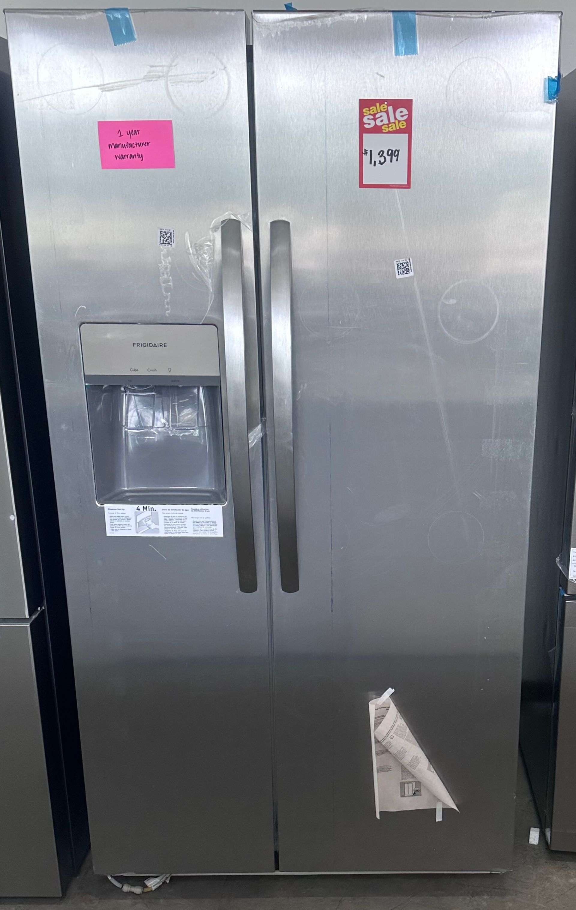 Stainless steel side-by-side refrigerator with water dispenser and pink labels on the doors