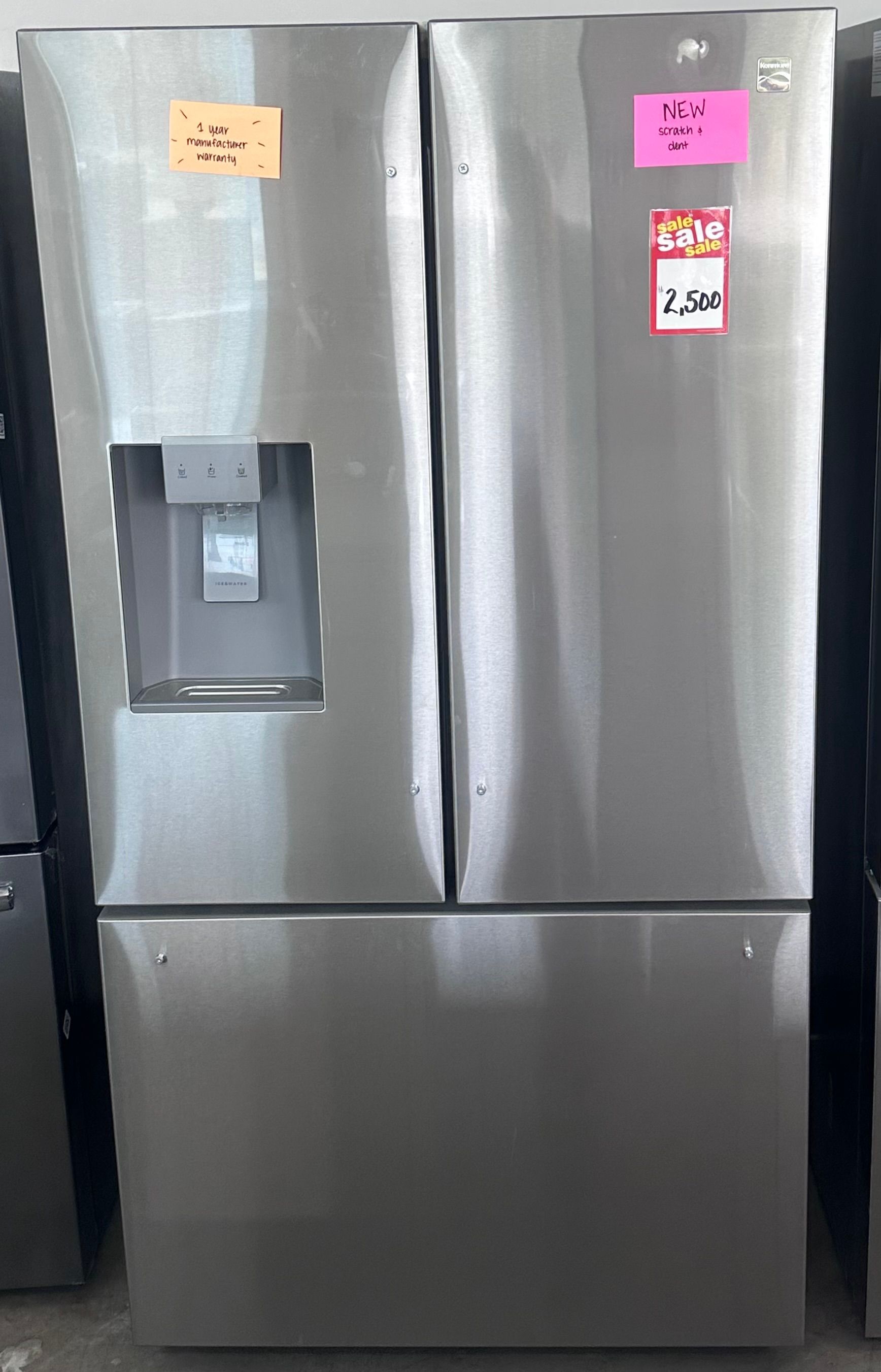 Stainless steel French door refrigerator with price tags.